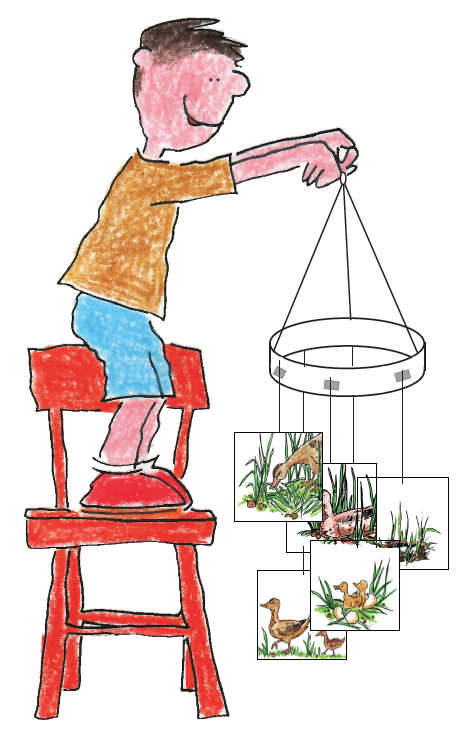 A child is standing on a chair and holding onto a mobile