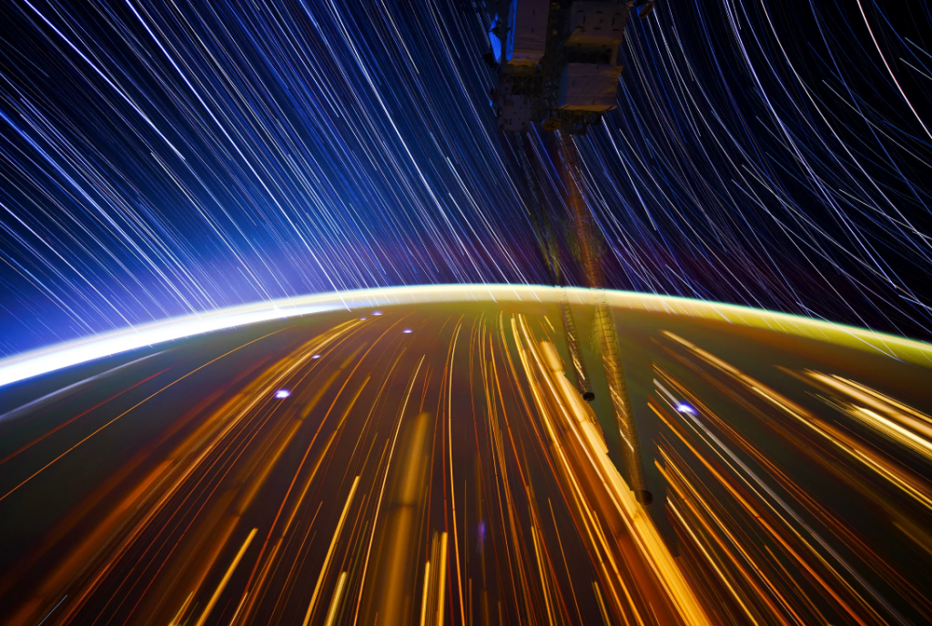 A view of the earth from space with star trails.
